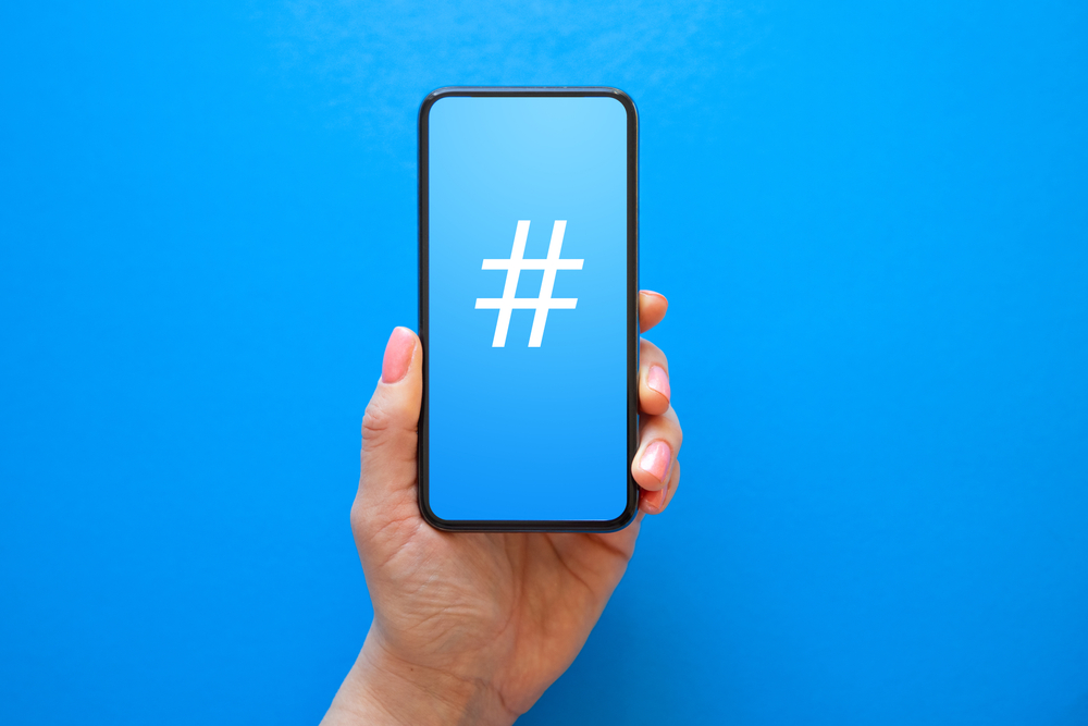 Phone in hand displaying blue screen with a white hashtag